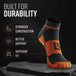 Black and orange quarter crew sock displayed on stone, showing MudGear branding and compression zones