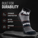 Black and gray quarter crew sock with MudGear branding displayed on rock surface