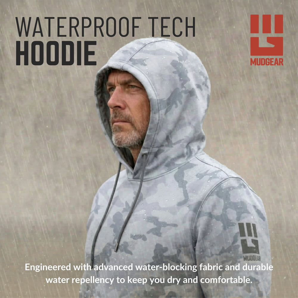 Man wearing light gray camo waterproof tech hoodie in rain with drawstring hood