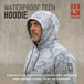 Man wearing light gray camo waterproof tech hoodie in rain with drawstring hood