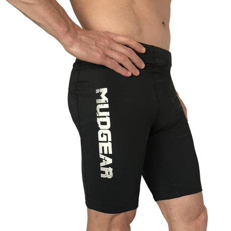 Man wearing black MudGear compression shorts with white logo text on thigh