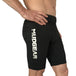 Man wearing black MudGear compression shorts with white logo text on thigh